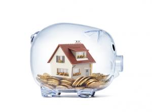 House on money inside transparent piggy bank with clipping path